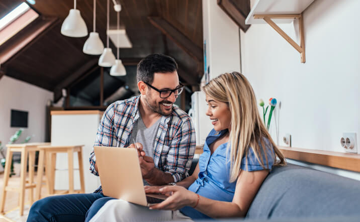 couple on couch shopping for flooring online